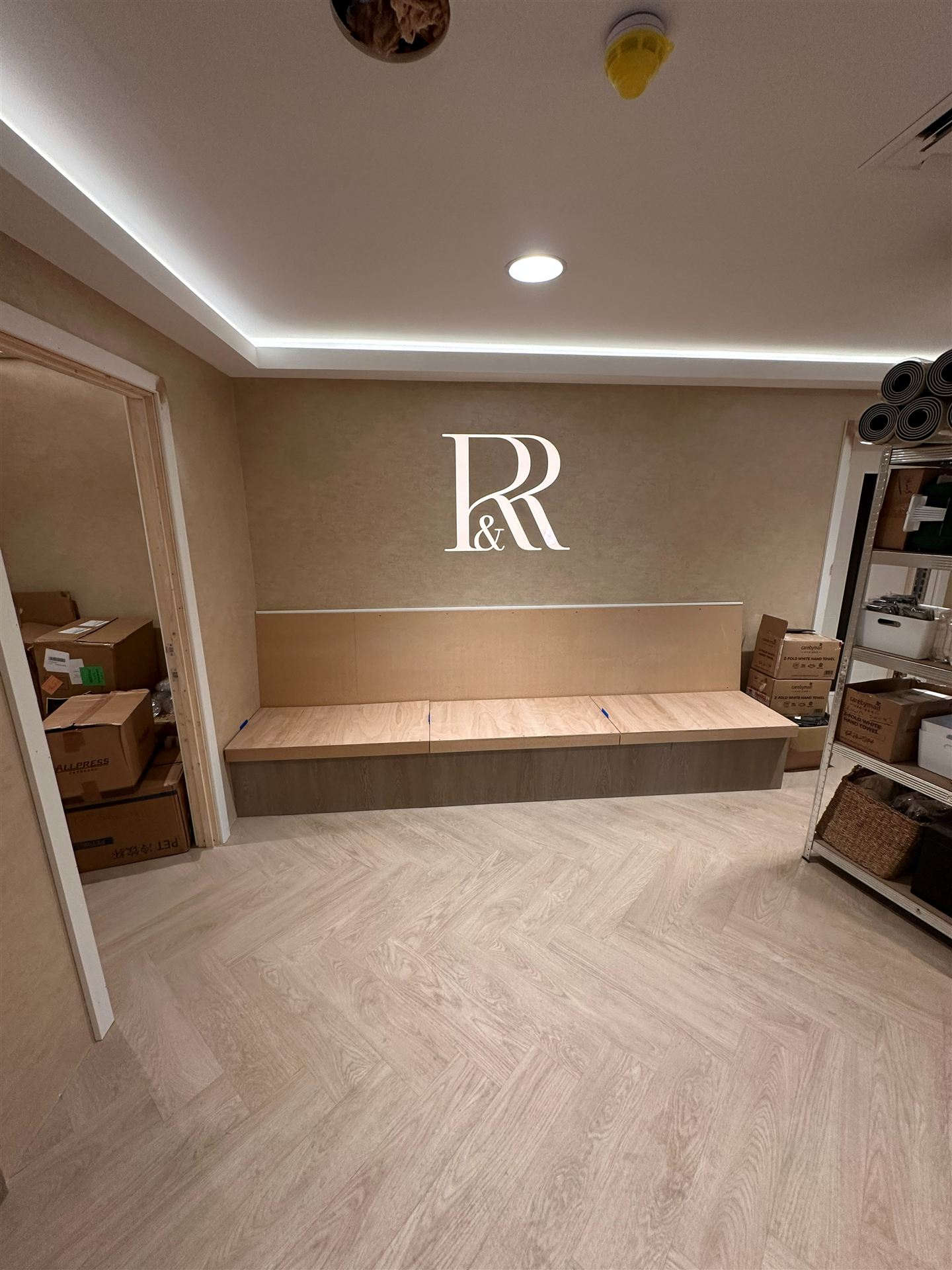 Finished waiting area with illuminated R and R sign and bench seating