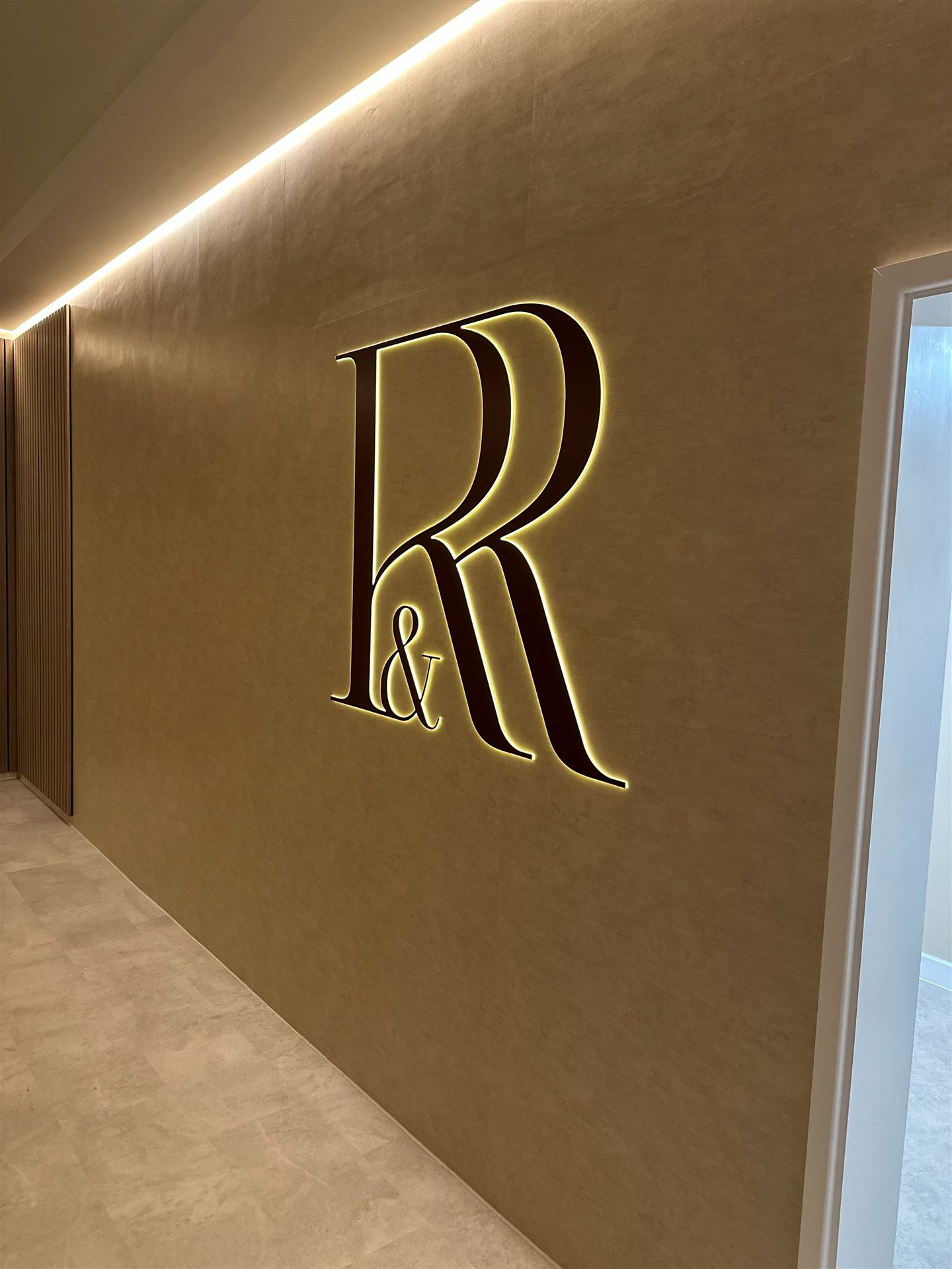 Illuminated Reform and Revive sign on feature wall